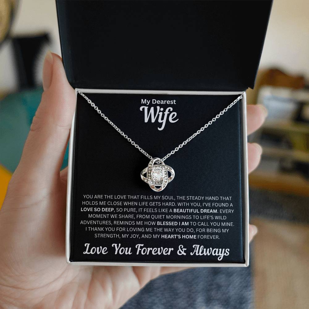 Hand holding Wife gift with love knot necklace and special message in a standard box