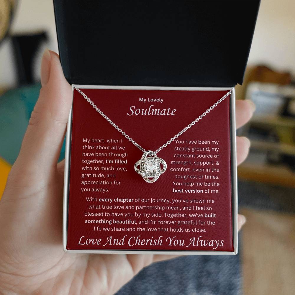Hand holding Soulmate gift with love knot necklace and special message , perfect for all occasions, in a standard box