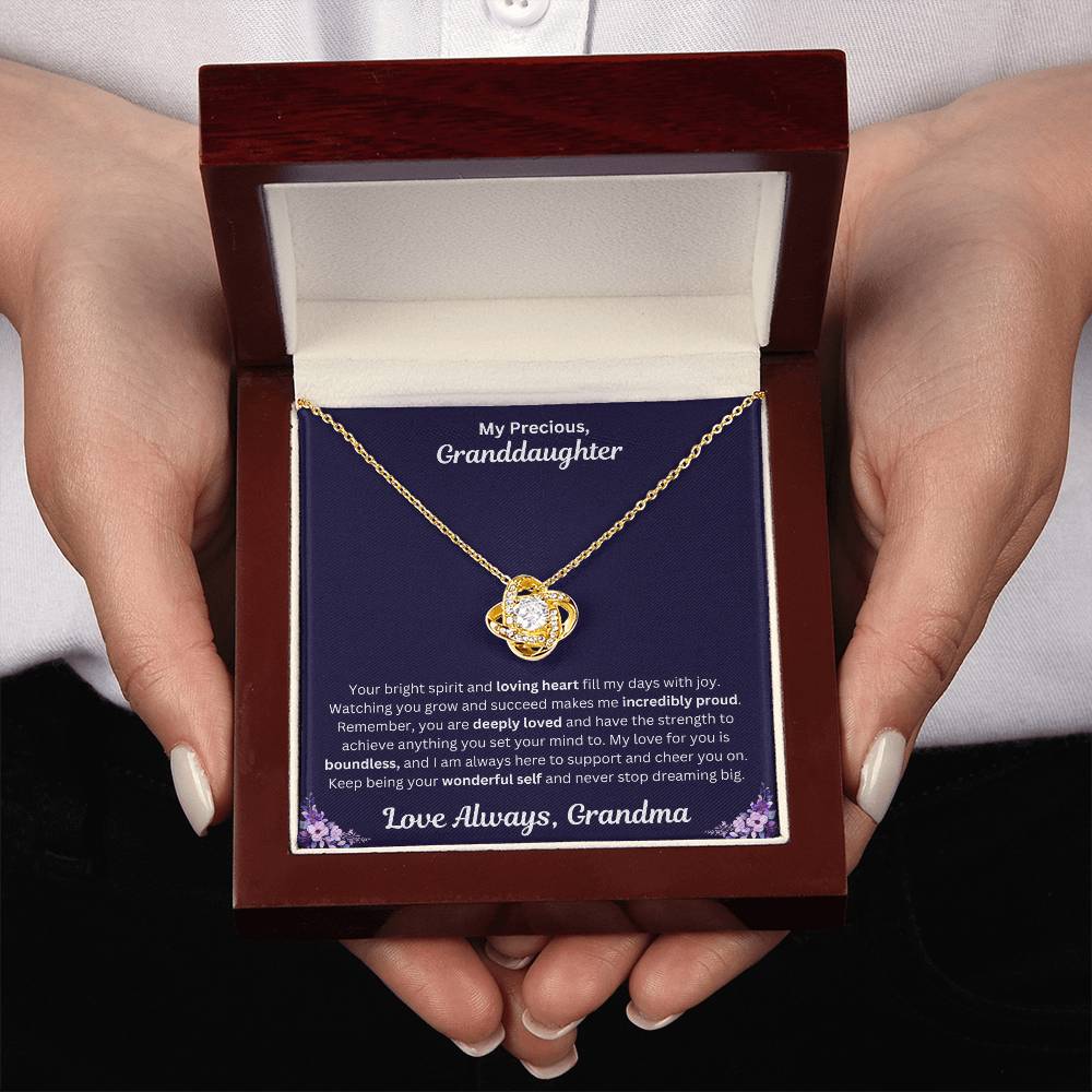 Hands holding Granddaughter gift from grandma with love knot necklace and special message in a luxury box