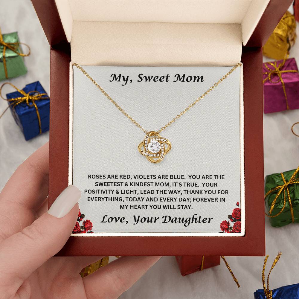 Hand holding the Mom gift from daughter with love knot necklace and special message in luxury box
