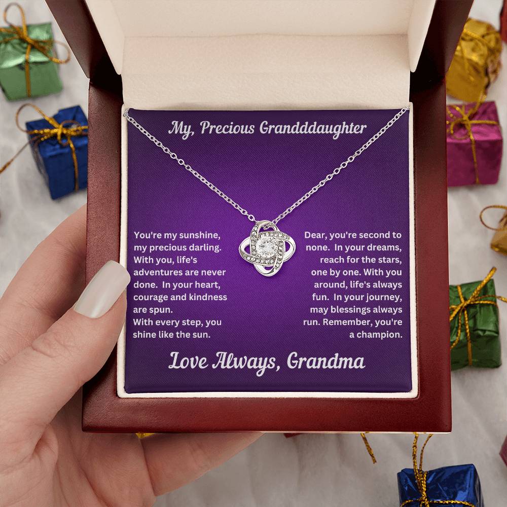 Hand holding Granddaughter gift from grandma with love knot necklace and special message in luxury box
