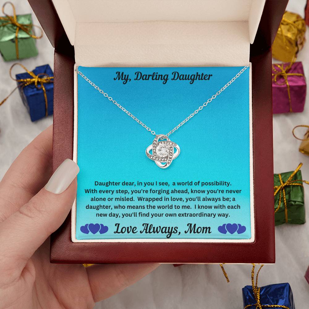 Hand holding Daughter gift from mom with love knot necklace and special message in luxury box