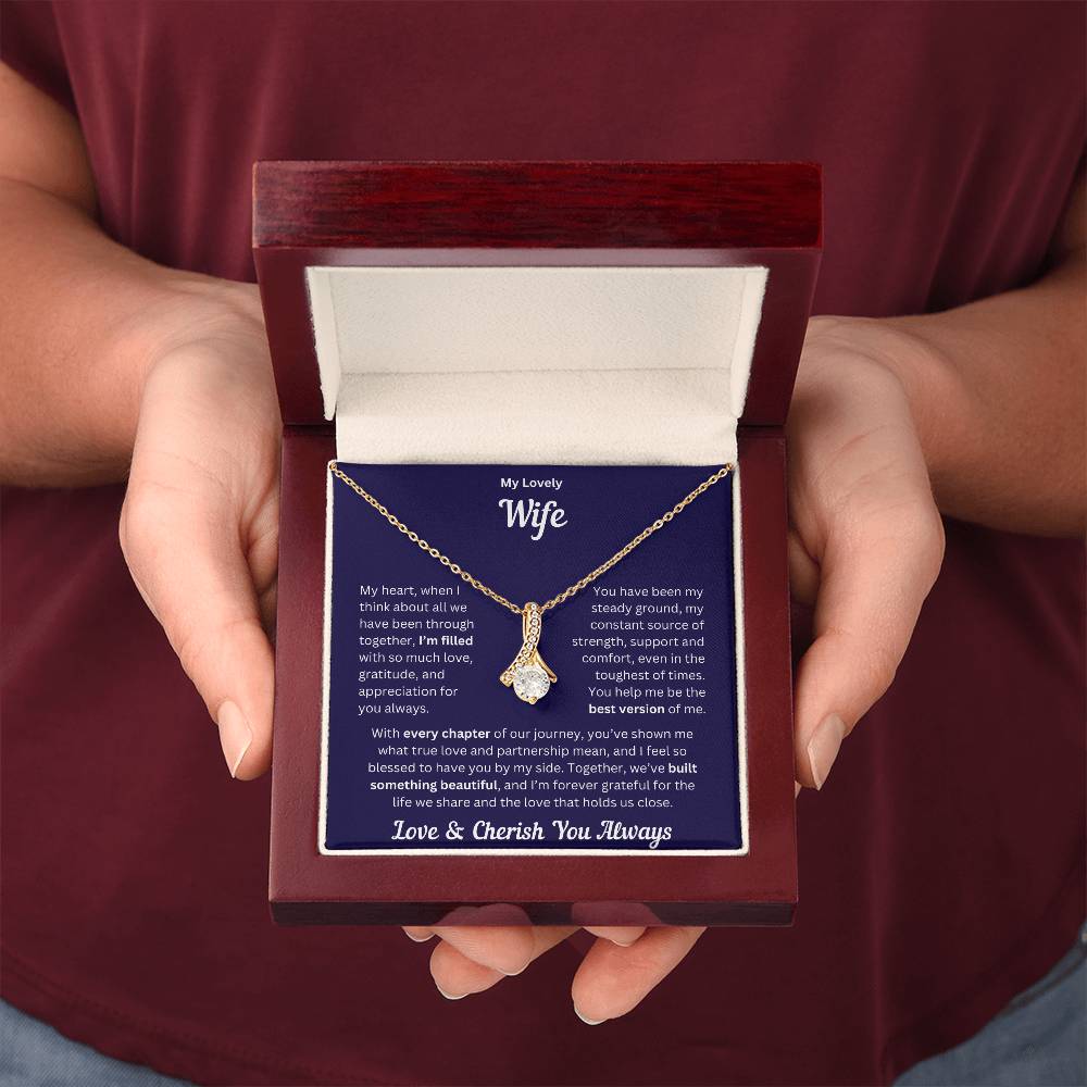 Hands holding Wife gift with alluring necklace and special message in a luxury box