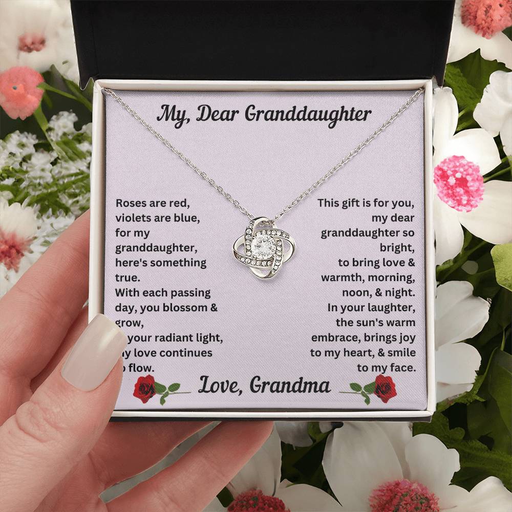 Hand holding Granddaughter gift from grandma with love knot necklace with special message in two tone box