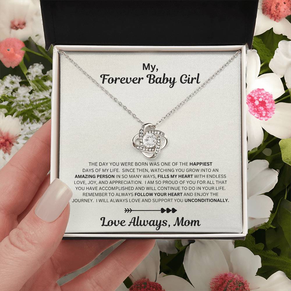 Hnad holding Daughter gift from mom with love knot necklace and sentimental message in standard box