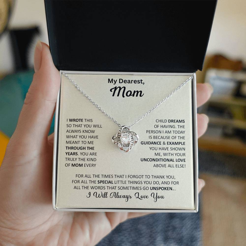 Hand holding Mom gift with love knot necklace and special message in two tone box