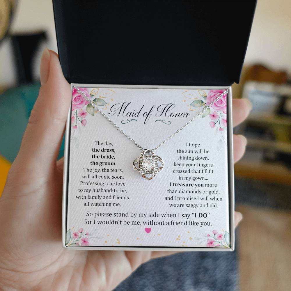 Hand holding Maid Of Honor gift with love knot necklace and special message in two tone box