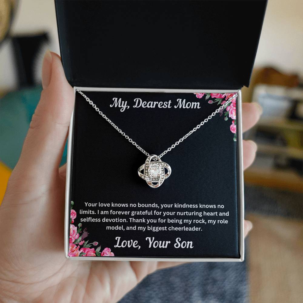 Hand holding Mom gift from son with love knot necklace and special necklace in two tone box