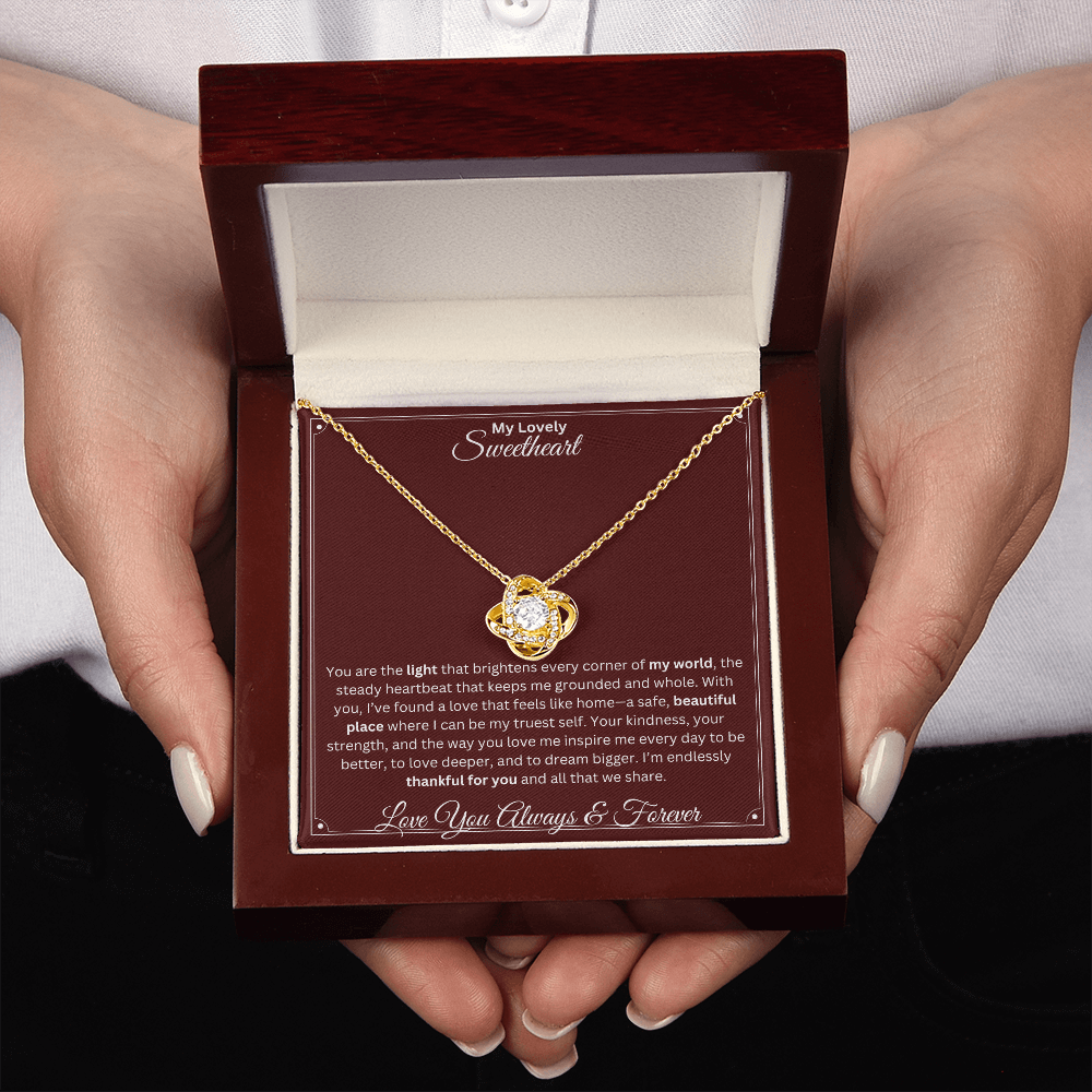 Two hands holding Soulmate gift with love knot necklace and special sentiment in a ready to gift box