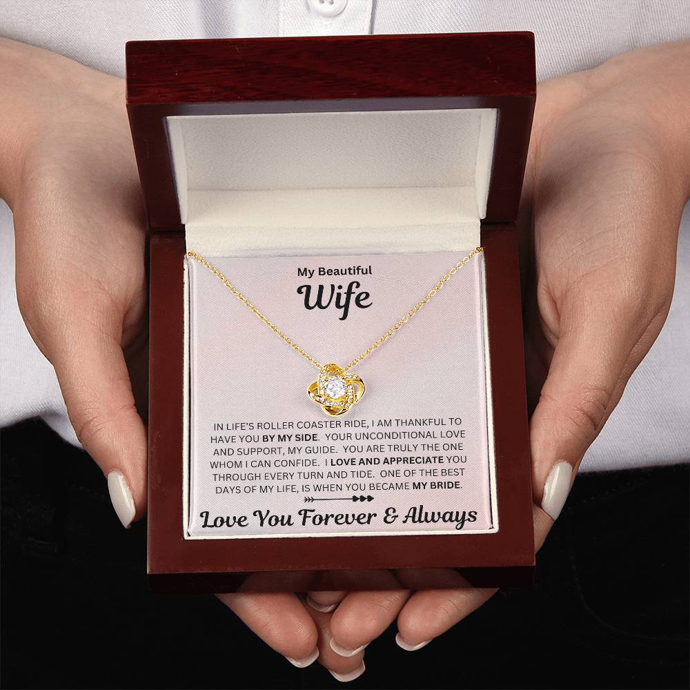 Hands holding Wife gift with love knot necklace and special sentiment in a luxury box