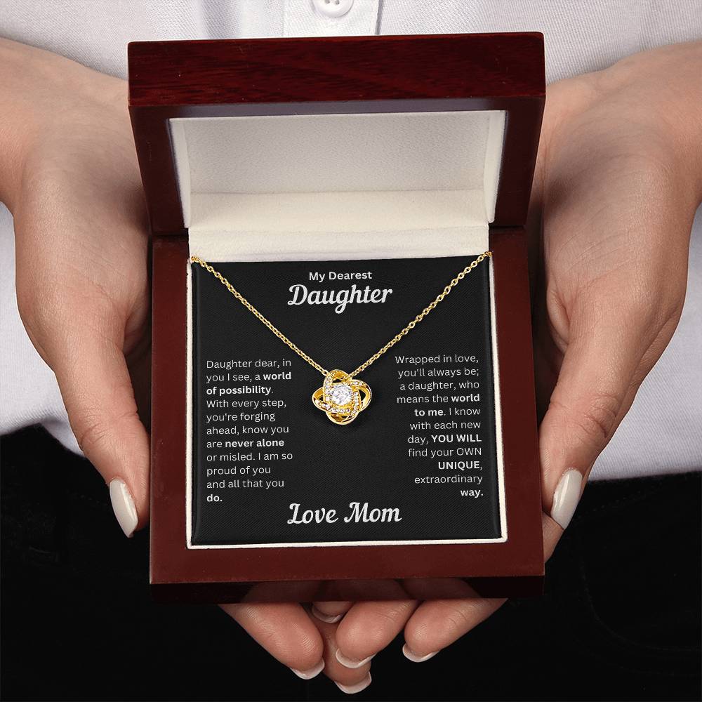 Hands holding Daughter gift from mom with love knot necklace and special message in a luxury box