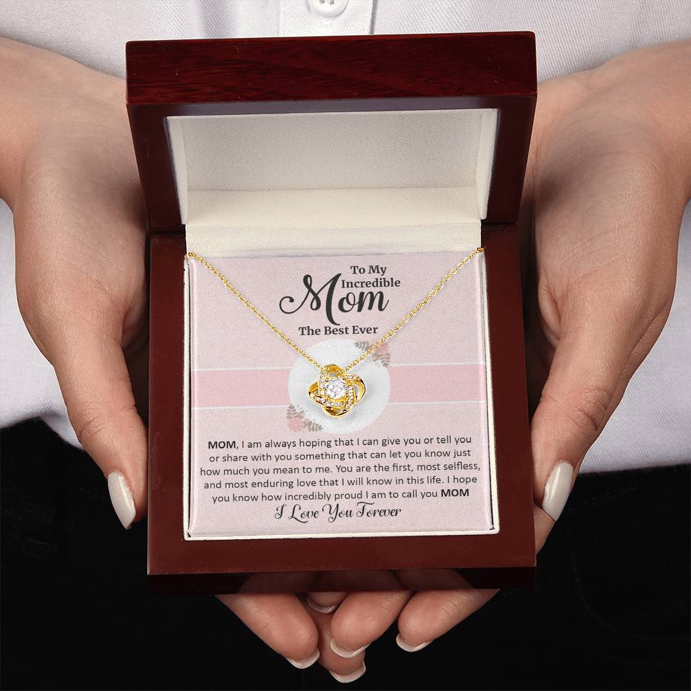 two  hands holding Gift for mom with love knot necklace and special message luxury box