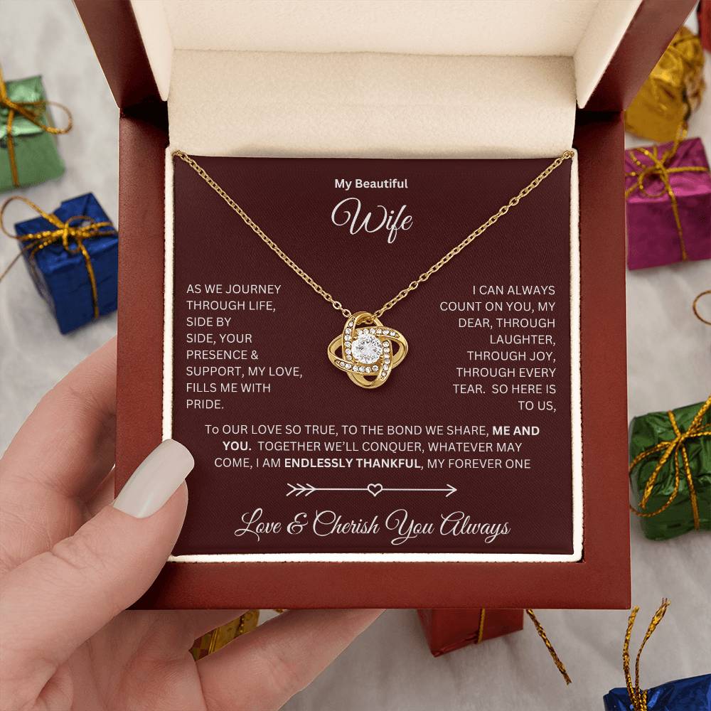 Hand holding Wife gift with love knot necklace and special message in a luxury box