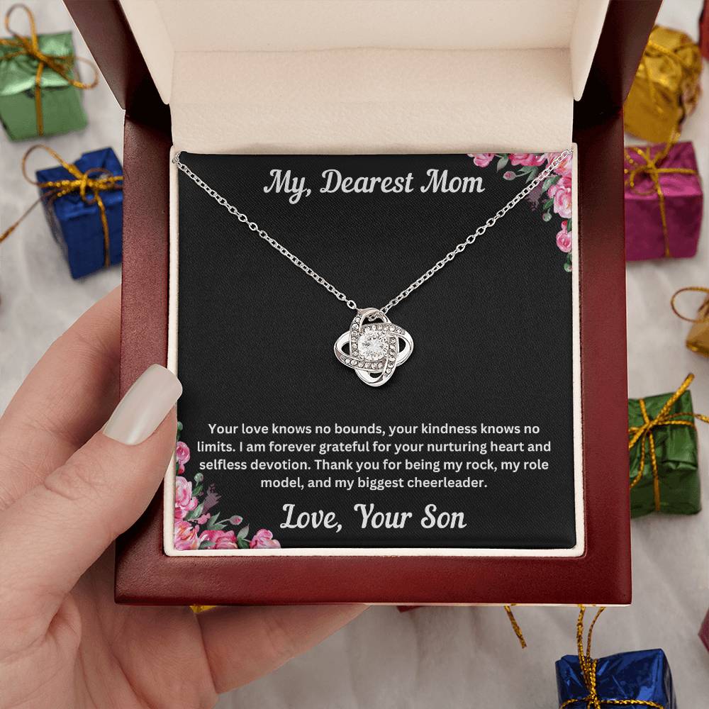 Hand holding Mom gift from son with love knot necklace and special necklace in luxury box