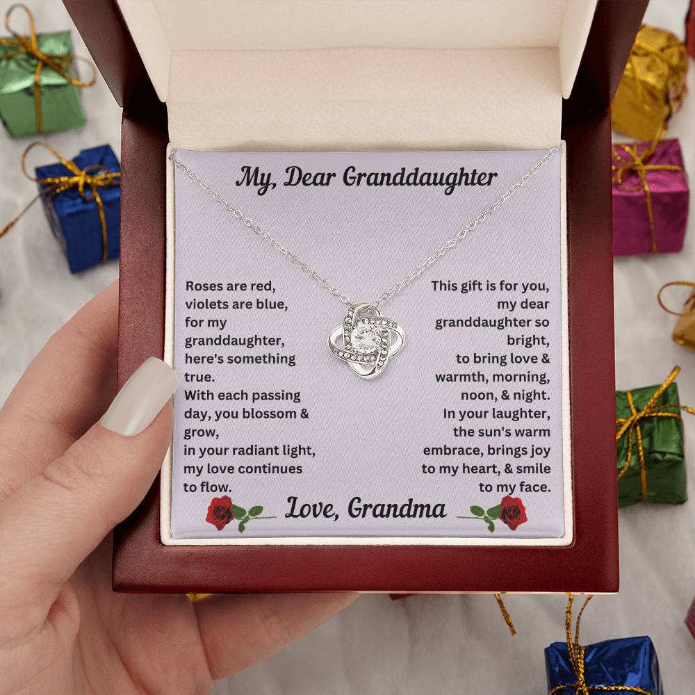 Hand holding the Granddaughter gift from grandma with love knot necklace with special message in luxury box