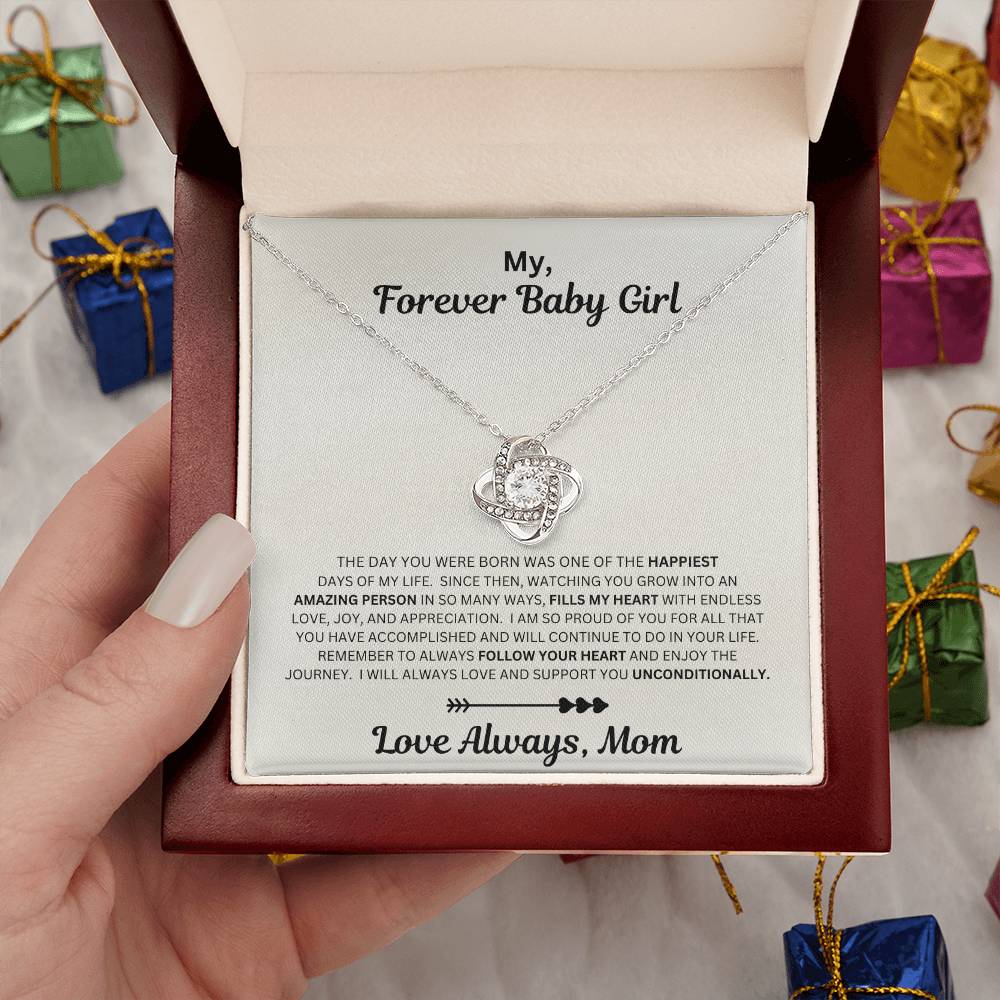 Hand holding Daughter gift from mom with love knot necklace and sentimental message in luxury box