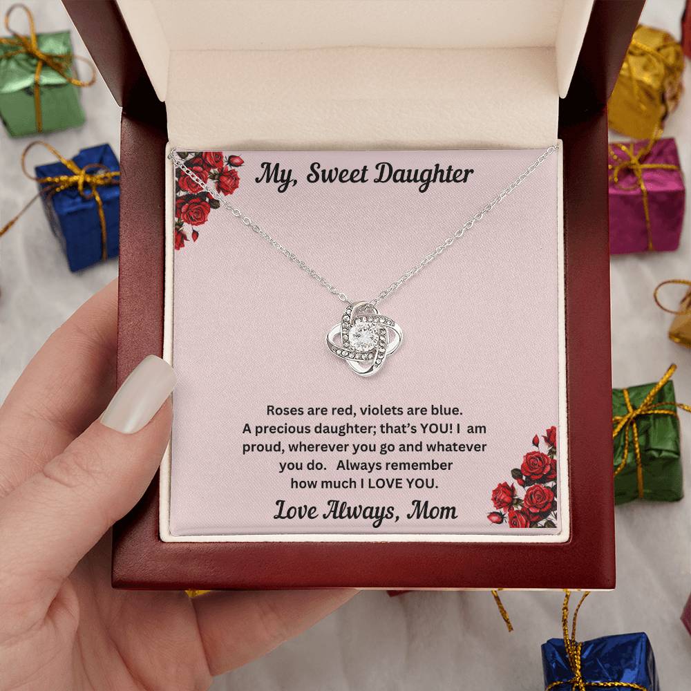 Hand holding Daughter gift from mom with love knot necklace and special message in luxury box