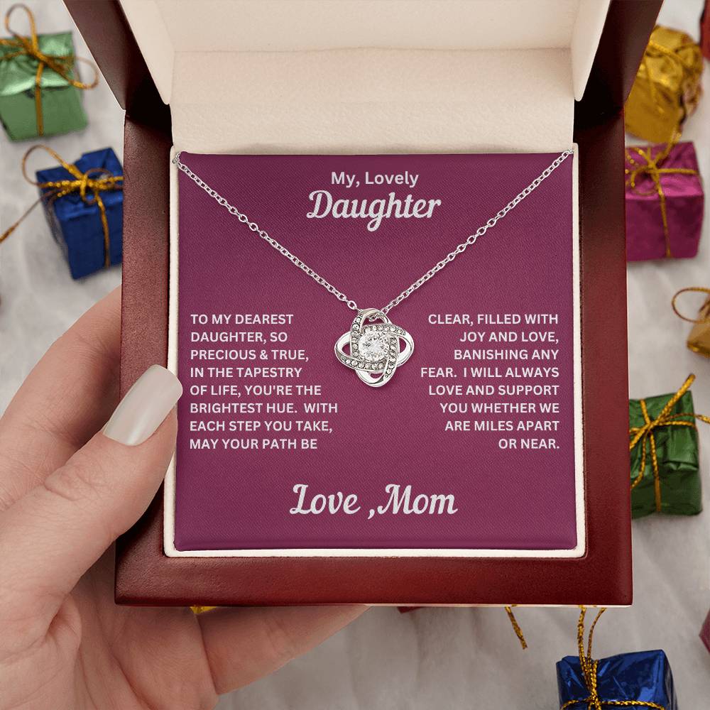 Hand holding the Daughter gift from mom with love knot necklace and special message in luxury box