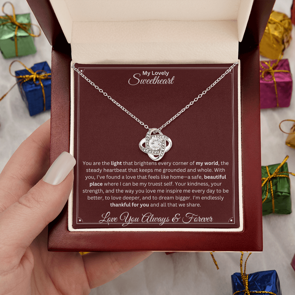 Hand holding Soulmate gift with love knot necklace and special sentiment in a ready to gift box