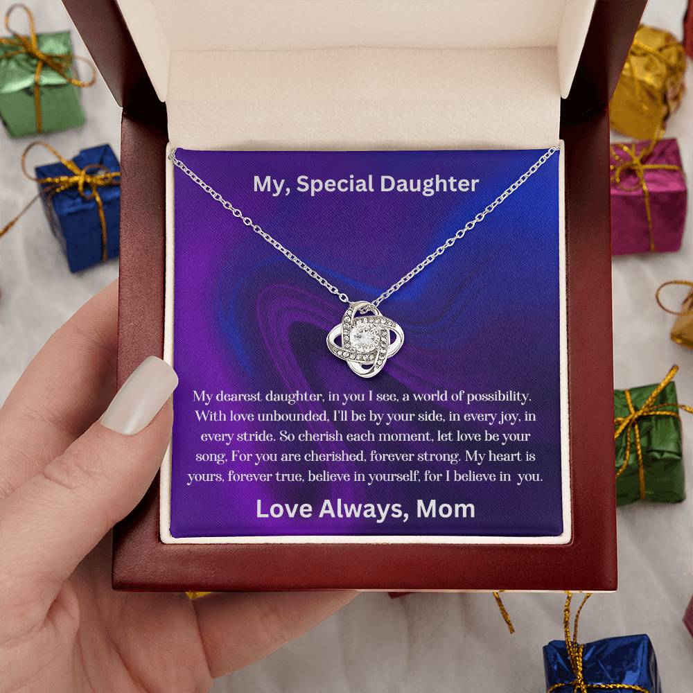 Hand holding the Daughter gift from mom with the love knot necklace and special message in luxury box